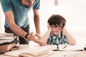 Obraz premium Little Boy in Glasses Doing Homework with Father.
