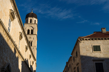 Fototapeta na wymiar Sunshined tower of St. Saviour church on blue sky in Dubrovnik, Croatia