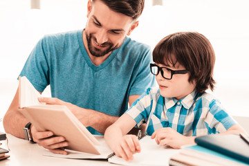 Little Boy in Glasses Doing Homework with Father.
