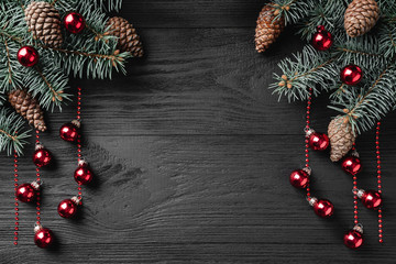 Holiday Christmas background with spruce branch on a dark wood table. Xmas and happy new year greeting card. Copy space. View from above. Flat location, place for text.