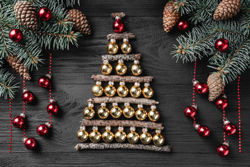 Christmas tree made of christmas balls  on a dark wooden background. Xmas and happy new year greeting card. Top view, flat lay