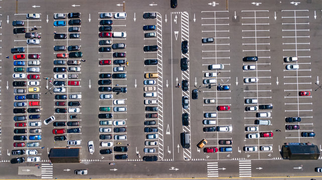 Aerial drone view of parking lot with many cars from above, city transportation and urban concept
