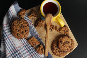 Cookies with chocolate chips and tea against dark background