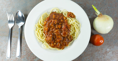 Spaghetti bolognese with tomato sauce and meat in a dish White on a stone floor table,Top view with copy space for your text..