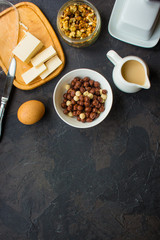 cornflakes, coffee, cottage cheese, bread, butter, eggs, jam and other ingredients for breakfast on a dark background. Top view with copy space
