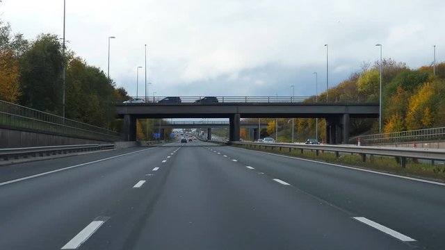 Car windshield view driving M62 motorway or highway at junction 9, going from Manchester to Liverpool, England, United Kingdom in autumn