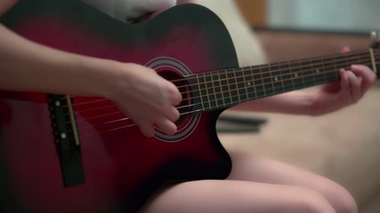 girl learning to play guitar