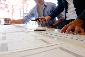 Team software development working with pre-project design application on mobile with paper.