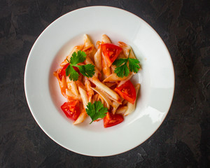 pasta, penne, tomato sauce and tomatoes. Vegan food.  (dark background). top view. copy space