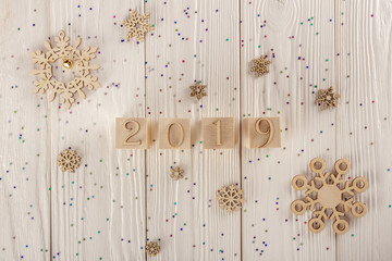 Christmas card, wooden cubes on a wooden background. Home cozy design. Happy new year 2019.