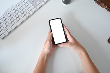Mockup smartphone on hands, top view office desk.