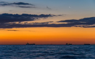 夜明け前の海。空に月