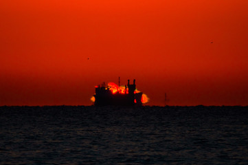 船の背後から昇る朝日