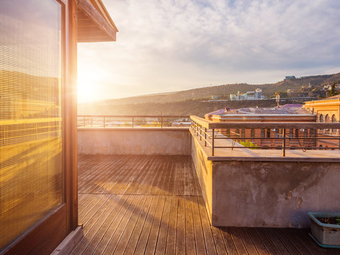 Large terrace with wooden floor in the apartment. View of Tbilisi. Georgia. Sunrise