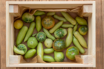 Red and green tomatoes on a wooden background. Tomato harvest