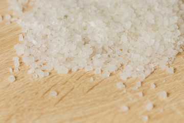 close up of sea salt for cooking and aromatherapy on  wooden background, selective focus