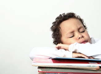 little boy sleeping on a pile of books