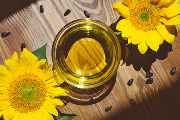 Sunflower oil and yellow flowers with seeds, food concept