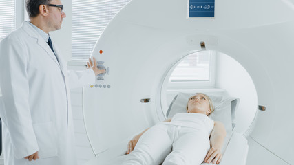 Obraz premium In Medical Laboratory Radiologist Controls MRI or CT or PET Scan with Female Patient Undergoing Procedure. High-Tech Modern Medical Equipment.