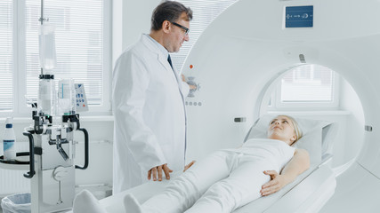 In Medical Laboratory Radiologist Controls MRI or CT or PET Scan with Female Patient Undergoing Procedure. High-Tech Modern Medical Equipment. Friendly Doctor Chats with Patient.