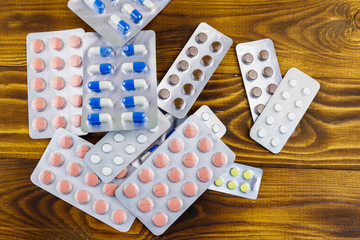 Different pills in blister pack on the wooden background