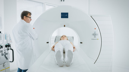 In Medical Laboratory Male Radiologist Controls MRI or CT or PET Scan with Female Patient...