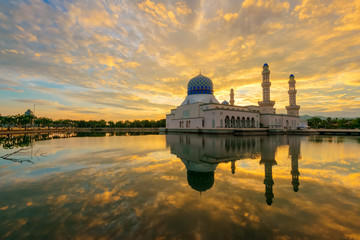 Dramatic fiery cloud on the sky and its reflection on the lake during sunrise captured at the beautiful floating mosque at Kota Kinabalu, Sabah, Malaysia.