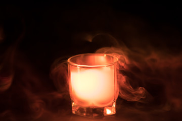 orange smoke (evaporation) in a glass bowl on a black background