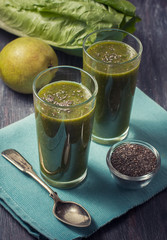 green smoothie with fruits and vegetables on black background