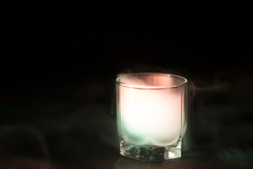 white, green smoke (evaporation) in a glass bowl on a black background