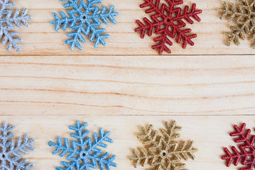 Colourful snowflakes frame on old wooden background