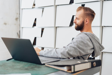 Young, casual man in contemplation at office desk