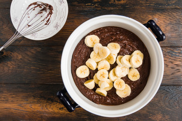 Sliced banana adding in whipped smooth chocolate dough