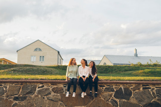 Three young women sitting on a wall in Karlskrona, Sweden