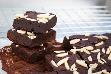 Dark chocolate brownies with almond topping on wire rack.