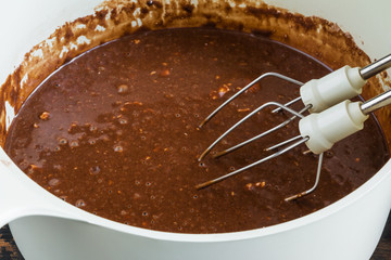 Whipped smooth chocolate dough for sweet cake and motor mixer