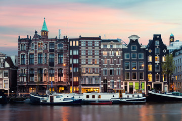 Fototapeta na wymiar Night Amsterdam city view of Netherlands traditional houses with Amstel river in Amsterdam, Netherlands