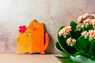 Enamoured cats, Valentine's day. Pink kalanchoe flowers.