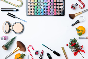 Photo on top of eye shadows, brushes, , tangerine, sugar cane on empty white table