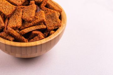 Rye salted crackers in wooden bowl on light marble background