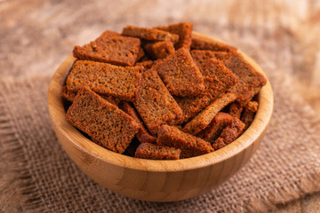 Rye salted crackers in wooden bowl on burlap napkin