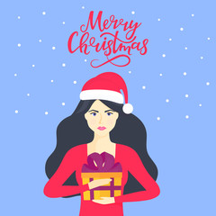 The girl in the cap of Santa Claus is holding a box with a gift. Merry Christmas hand lettering.