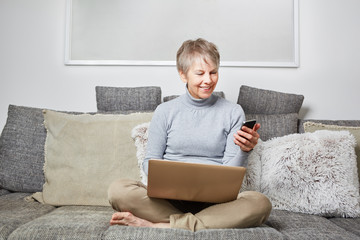 Seniorin liest Nachricht auf Smartphone