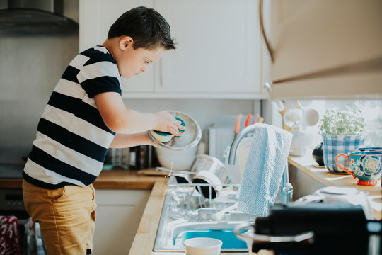 Little boy doing the dishes