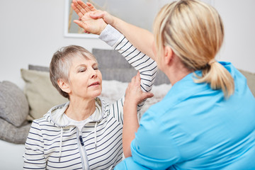 Therapeutin macht Ergotherapie mit Seniorin