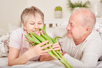 Ältere Frau bekommt Blumen geschenkt