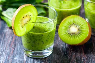 Fototapeta na wymiar Healthy green smoothie from spinach and kiwi on a wooden table