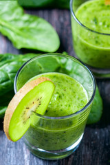 Healthy green smoothie from spinach and kiwi on a wooden table