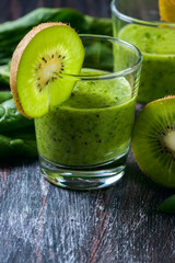 Fototapeta na wymiar Healthy green smoothie from spinach and kiwi on a wooden table