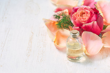 Bottle with essential aroma oil on white wooden background.